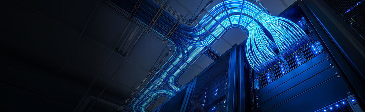 Glowing blue network cables in data center