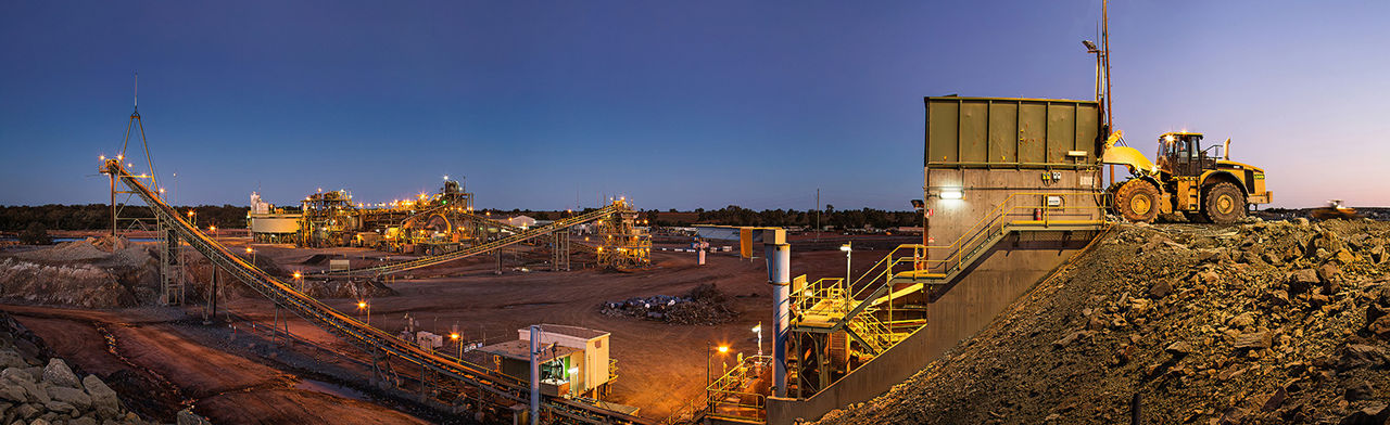 Bulldozer loading rocks into the crusher within the copper mine head at dusk in NSW Australia