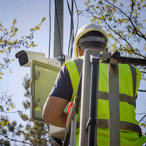 Utility engineer setting up surveillance camera.