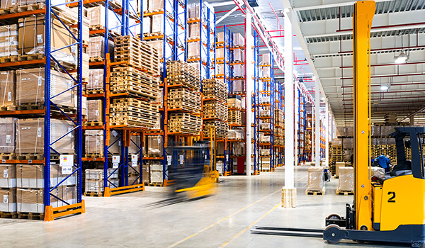 Forklifts driving through warehouse