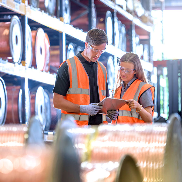 Workers with copper reels in warehouse